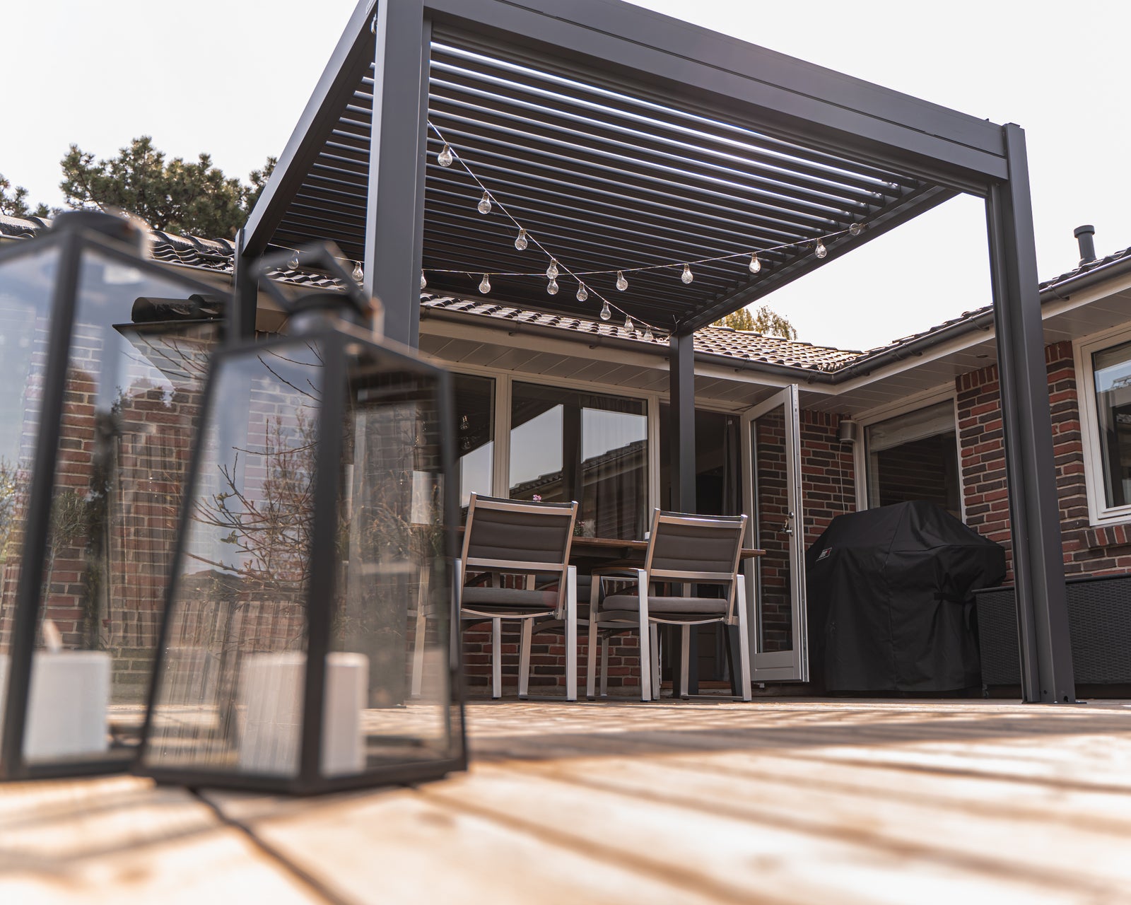 Anthricite pergola model with fairy lights and louvered roof that is adjustable